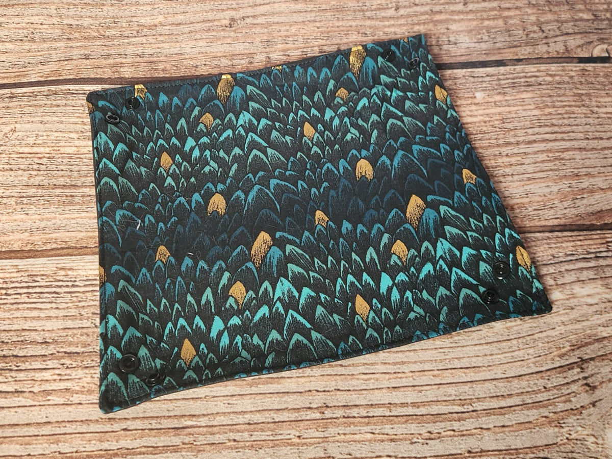 Handmade dragon-scale dice tray laid flat before snapping the corners, showing the teal, black, and metallic gold fabric and the corner snap fasteners.